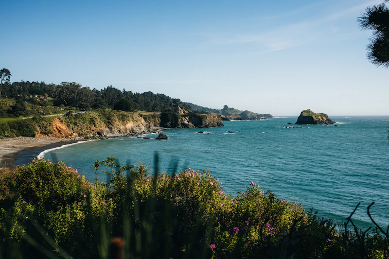 A sunny coastline with rocky cliffs and turquoise water